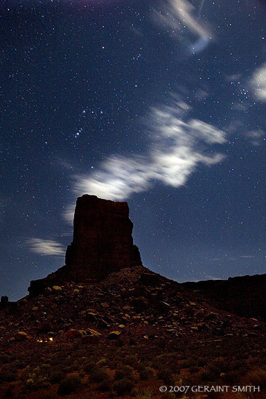 Camping under the starry skies of south east Utah in Valley of the Gods. The constellation Orion is visable dirtectly above the butte. The lens flare in the top of the picture is from the moon.