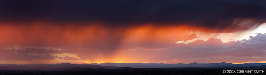 A Taos sunset across the mesa through the rain