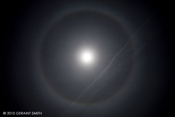 Moon halo and an airplane vapor trail