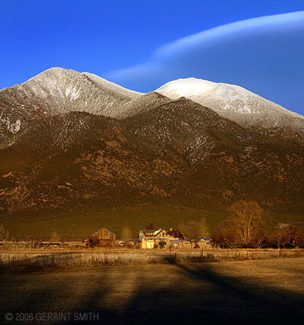 Long shadows of the evening, a ranch, and Taos mountain, New Mexico