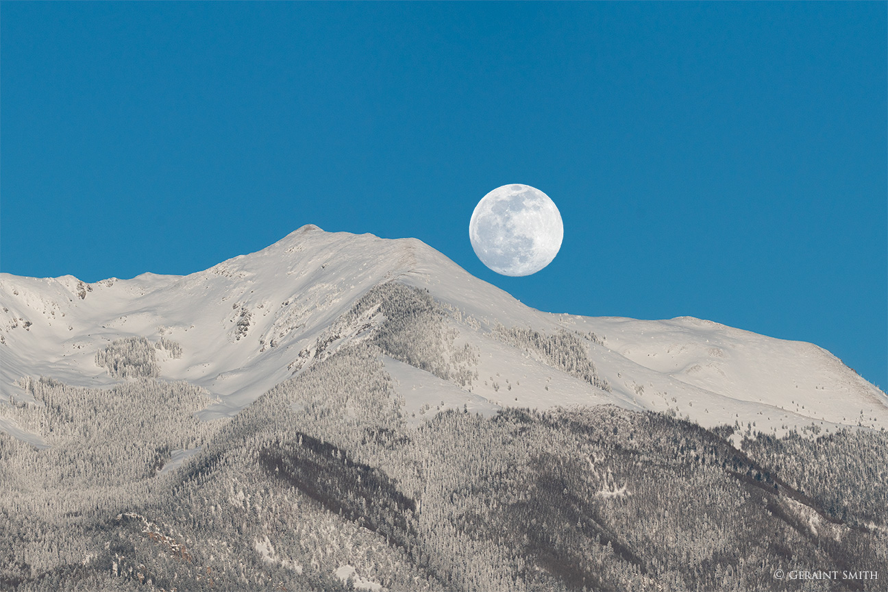 Wolf Moon over snow capped peaks