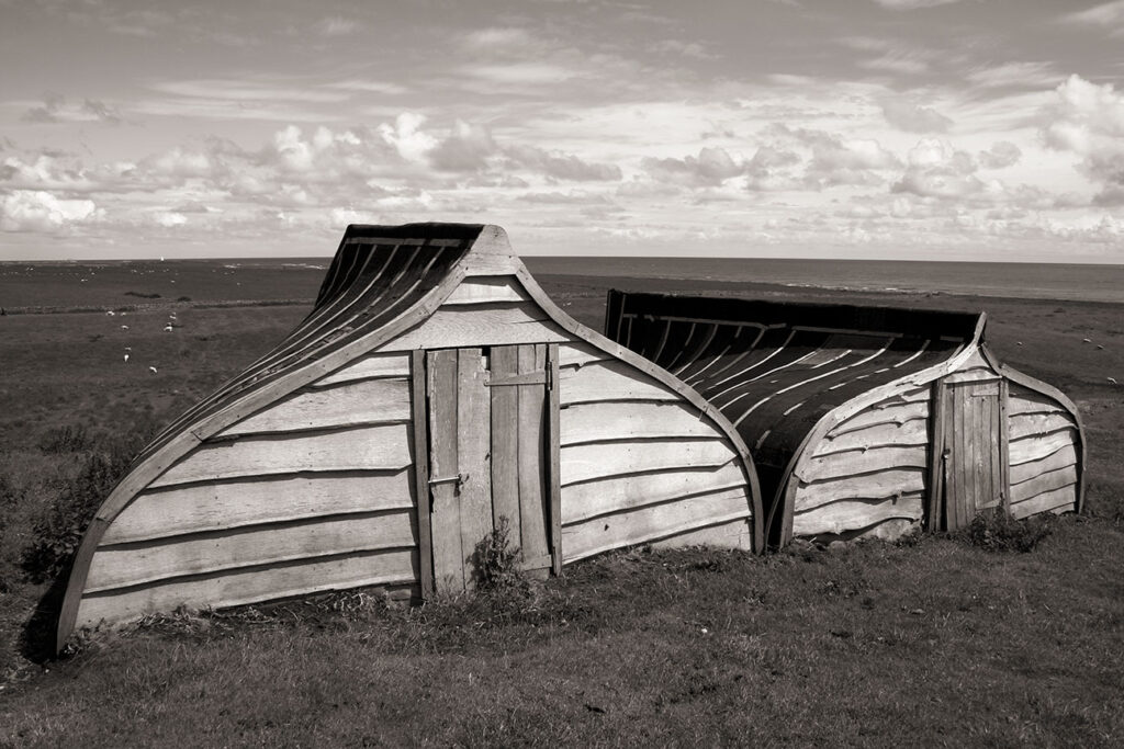 Two overturned boat storage sheds
